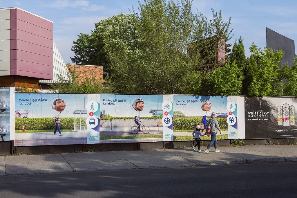 Affichage sauvage dans une rue de Montréal représentant les trois affiches de la campagne sur le transport actif.