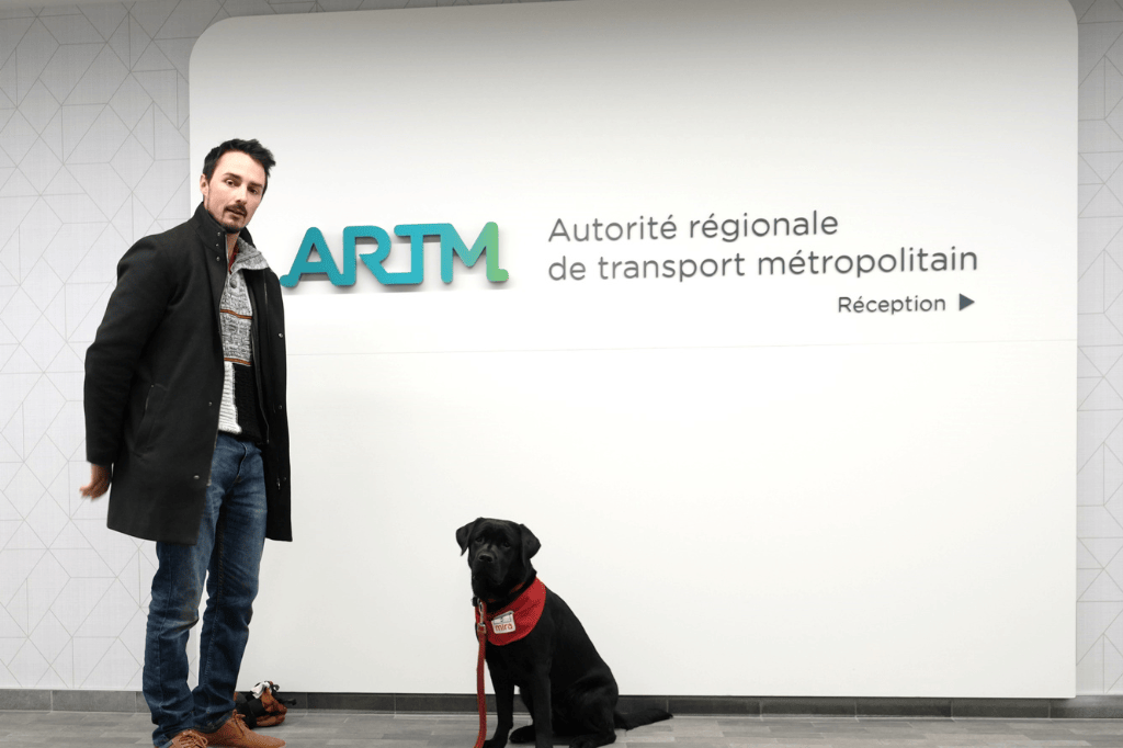 Le maître et son chien-guide à l'entrée des bureaux de l'ARTM.