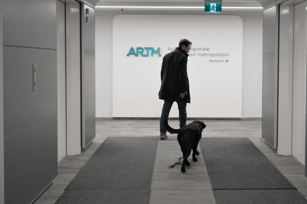 Chien-guide avec son maître qui quitte le bureau ARTM.